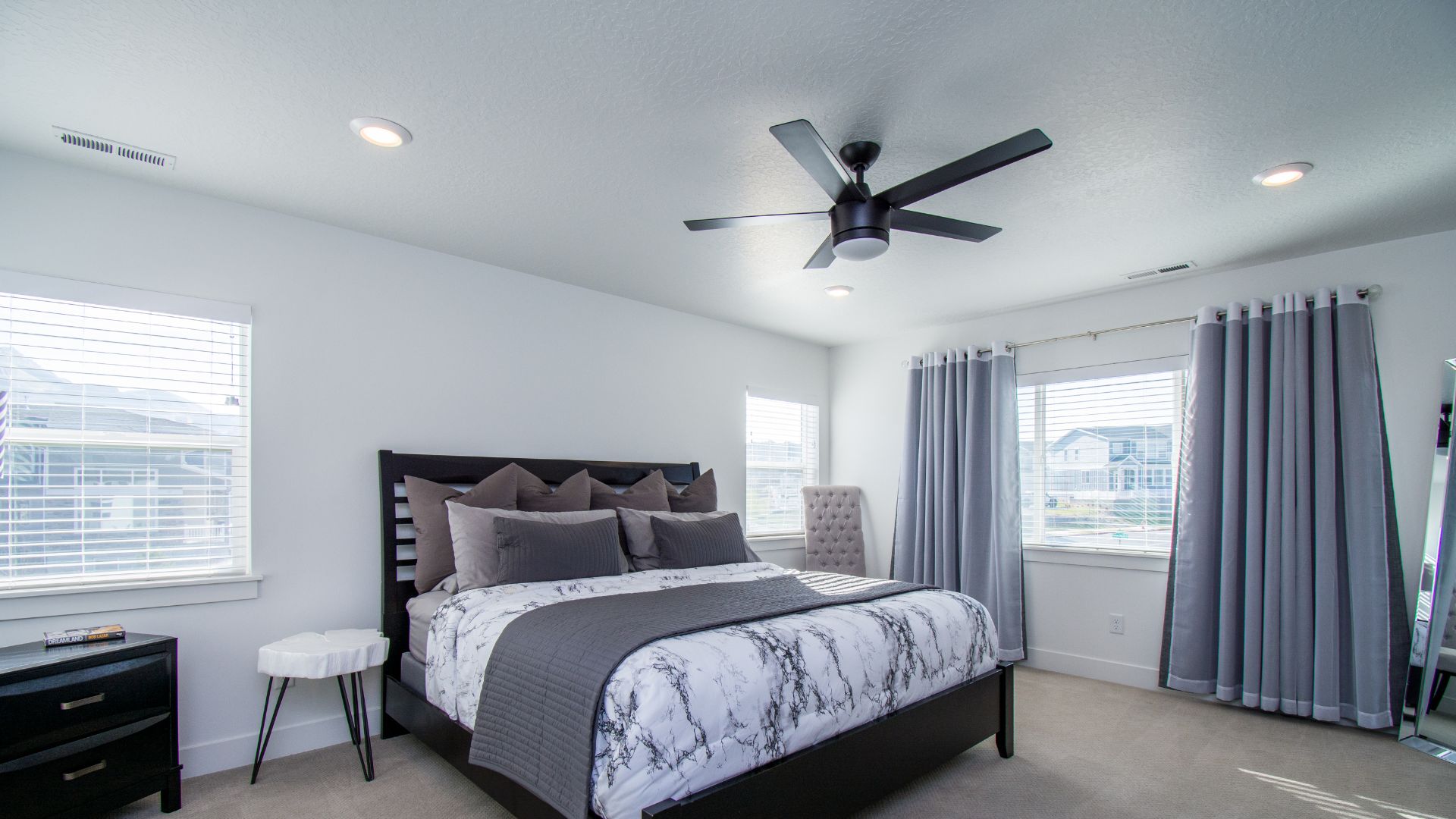 A bedroom with a large bed and a ceiling fan